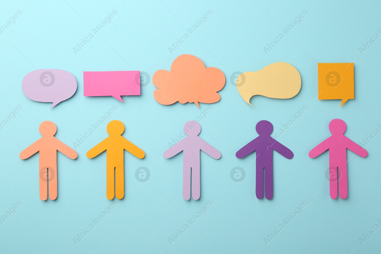 Photo of Equality concept. Paper human figures and different speech bubbles on light blue background, flat lay