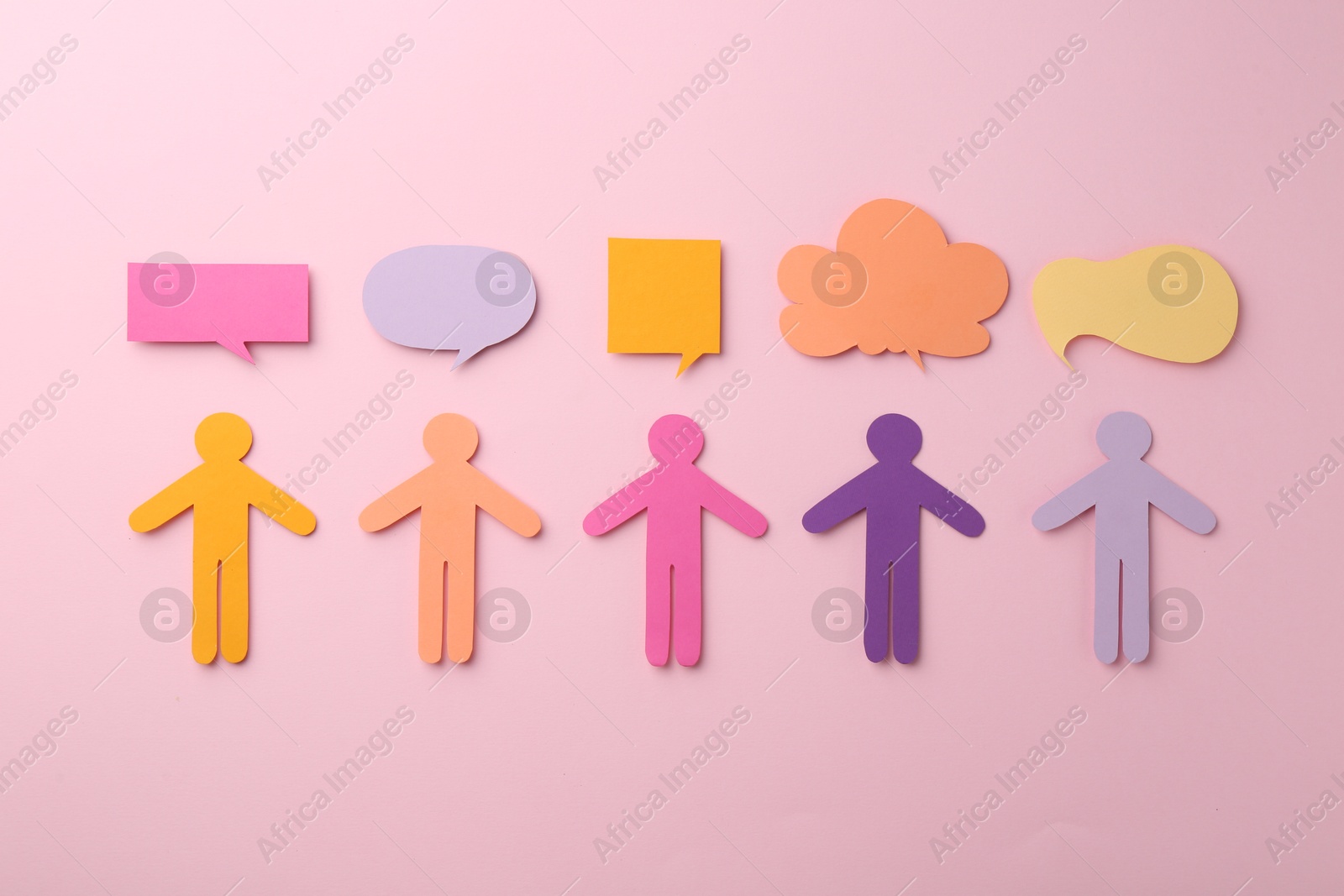 Photo of Equality concept. Paper human figures and different speech bubbles on pink background, flat lay