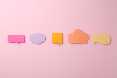 Photo of Equality concept. Different paper speech bubbles on pink background, flat lay