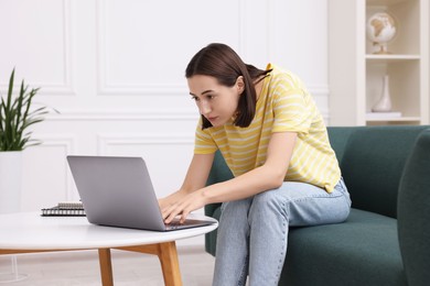 Woman with poor posture using laptop at home