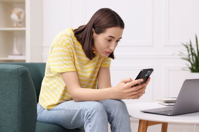 Photo of Woman with poor posture using smartphone at home