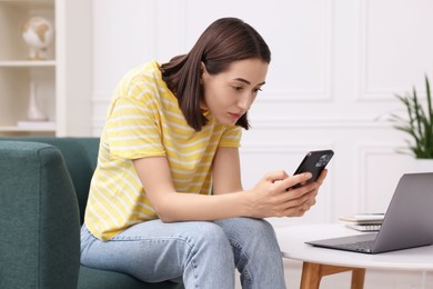 Woman with poor posture using smartphone at home