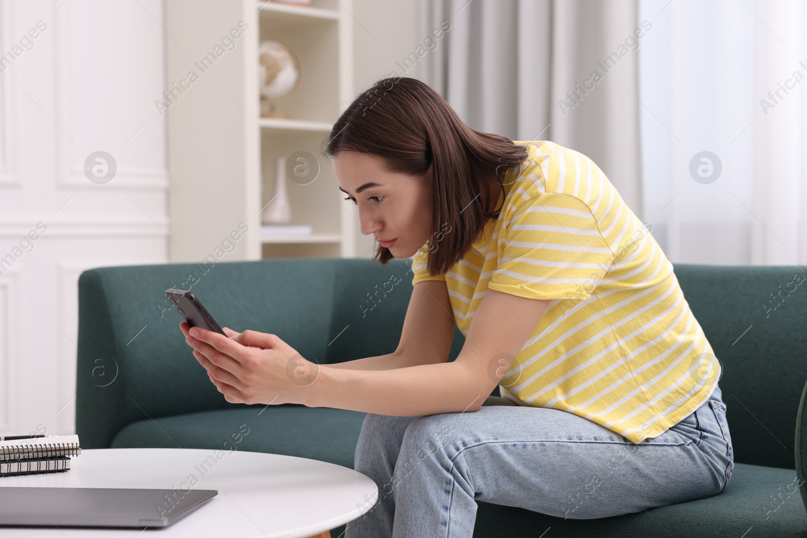 Photo of Woman with poor posture using smartphone at home