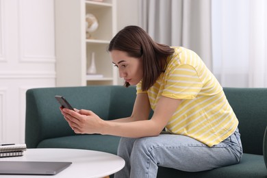 Woman with poor posture using smartphone at home