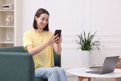 Photo of Woman with good posture using smartphone at home