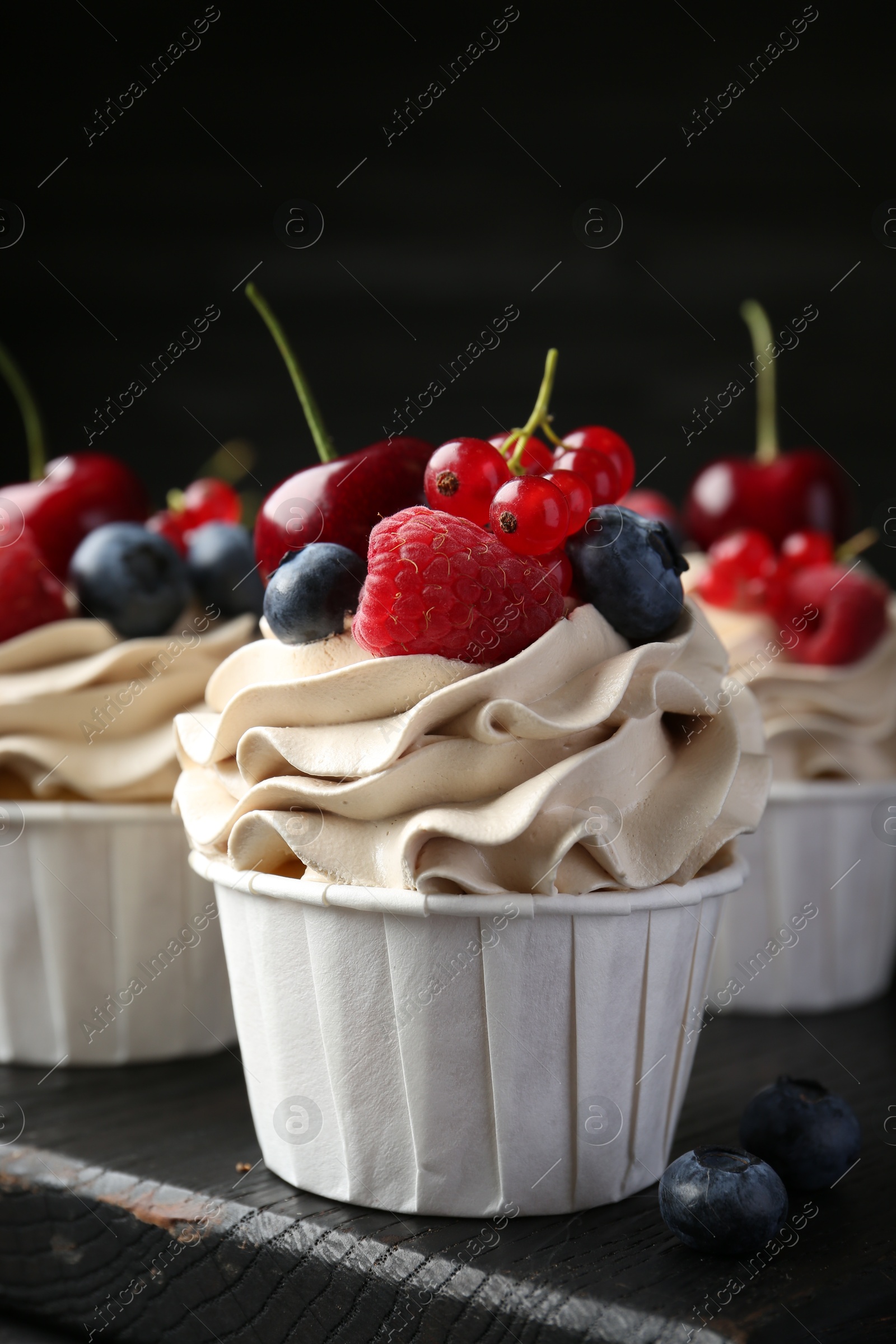 Photo of Tasty cupcakes with different berries on table, closeup