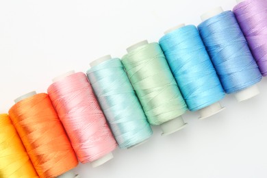 Spools of sewing threads on white background, flat lay