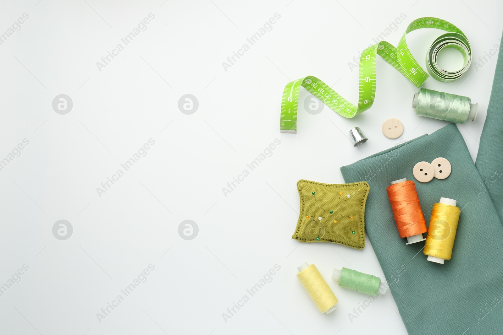 Photo of Flat lay composition with different sewing supplies on white background. Space for text