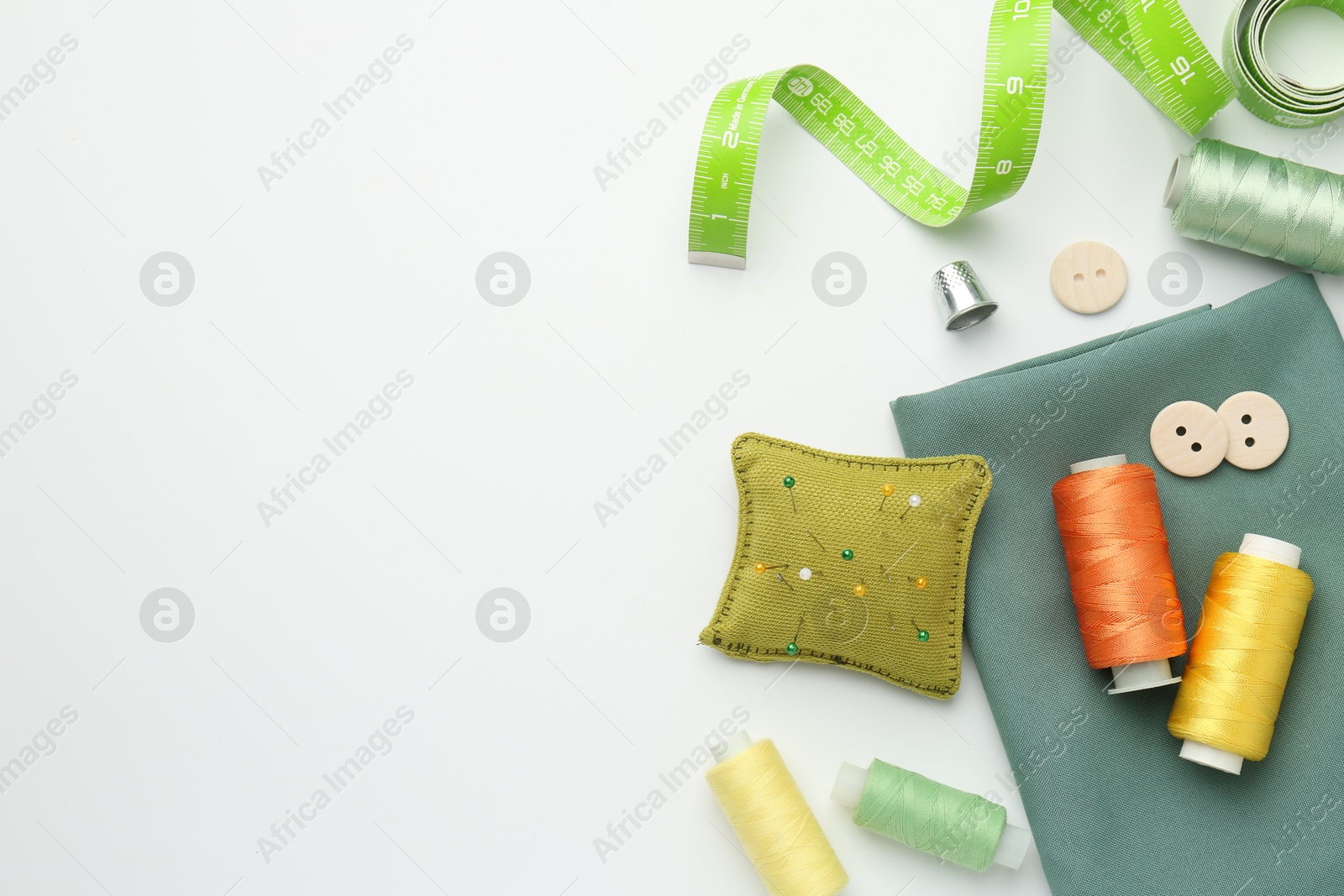 Photo of Flat lay composition with different sewing supplies on white background. Space for text