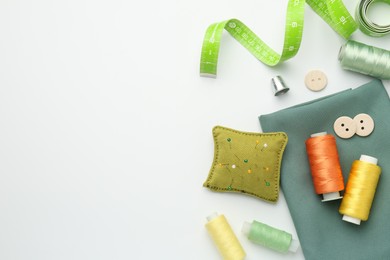 Photo of Flat lay composition with different sewing supplies on white background. Space for text