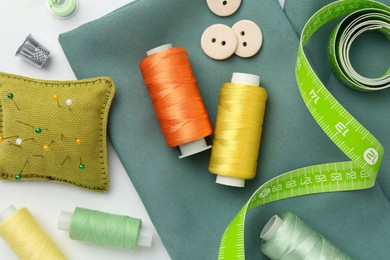 Photo of Flat lay composition with different sewing supplies on white background