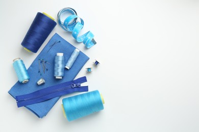 Photo of Flat lay composition with different sewing supplies on white background. Space for text