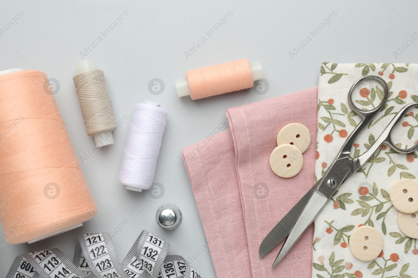 Photo of Flat lay composition with different sewing supplies on light grey background