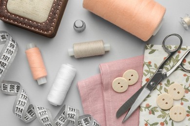 Photo of Flat lay composition with different sewing supplies on light grey background