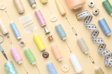 Photo of Flat lay composition with different sewing supplies on beige background