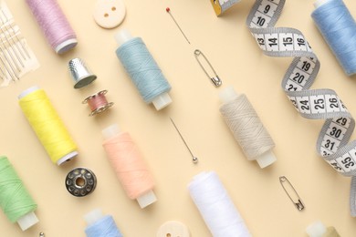 Photo of Flat lay composition with different sewing supplies on beige background