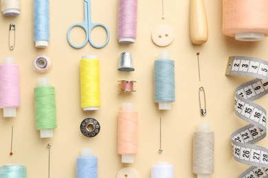 Photo of Flat lay composition with different sewing supplies on beige background