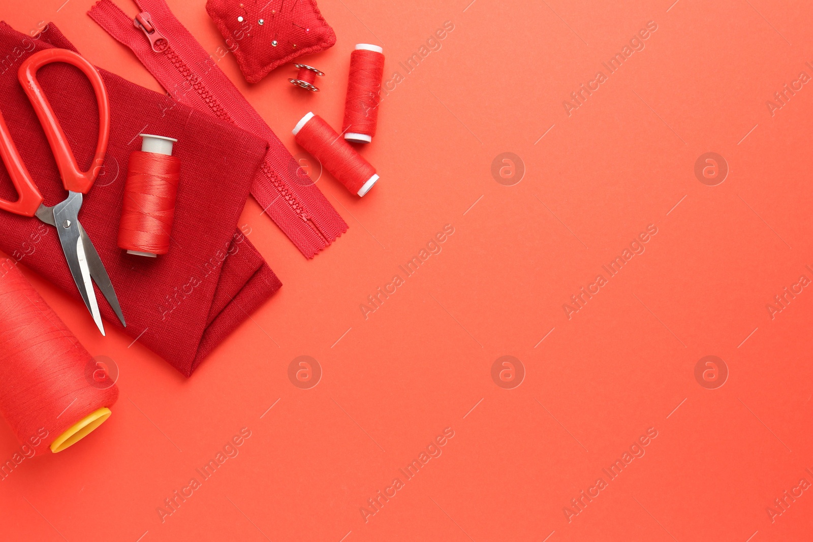 Photo of Flat lay composition with different sewing supplies on coral background. Space for text