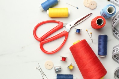 Photo of Flat lay composition with different sewing supplies on white table. Space for text