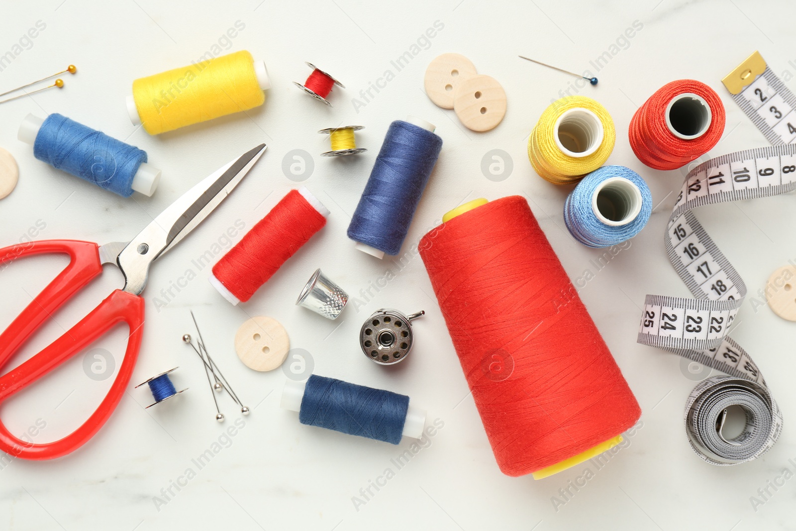 Photo of Flat lay composition with different sewing supplies on white table