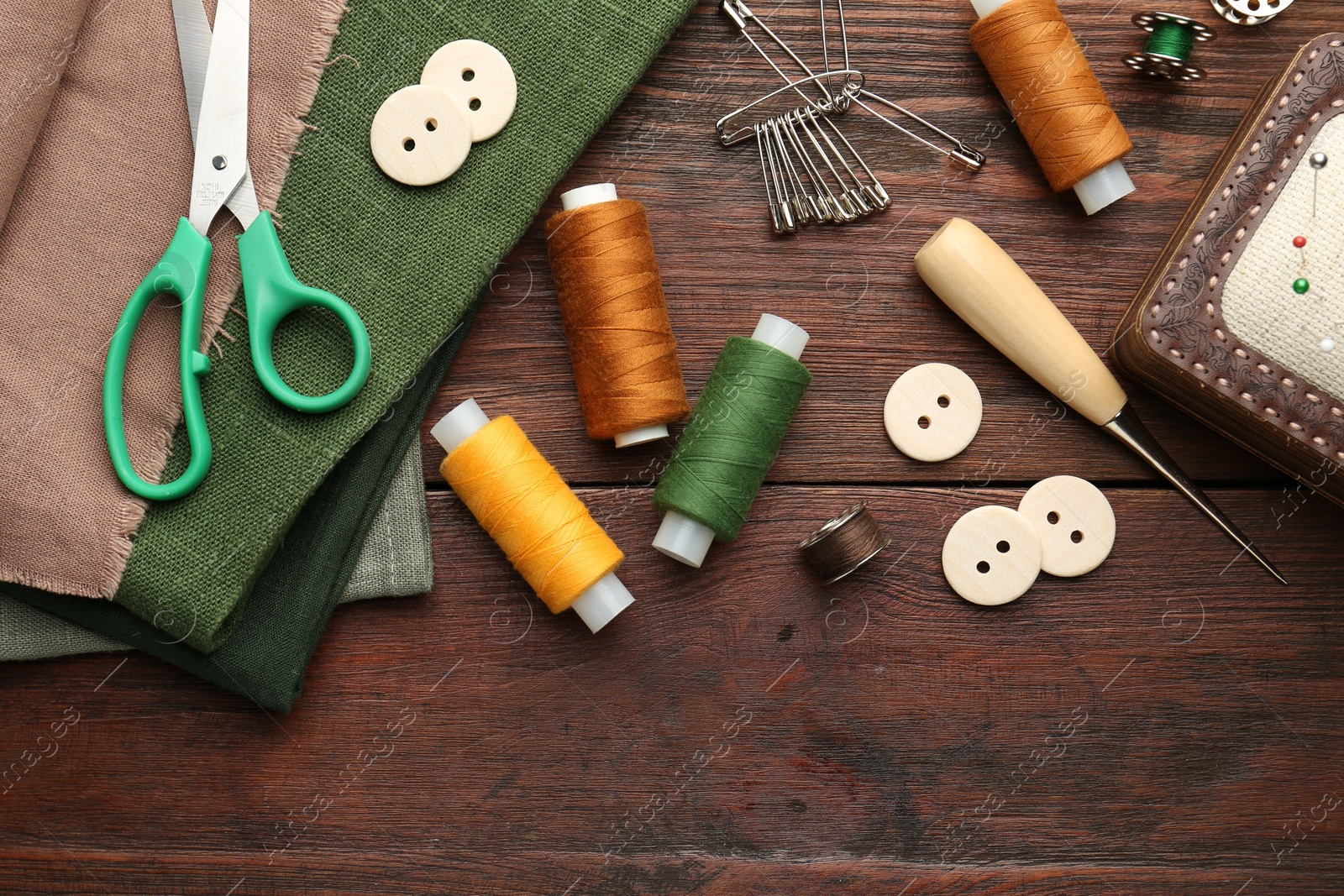 Photo of Flat lay composition with different sewing supplies on wooden table