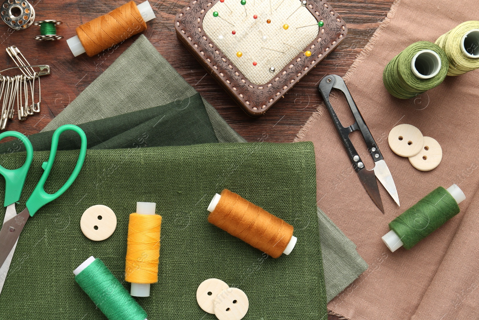 Photo of Flat lay composition with different sewing supplies on wooden table