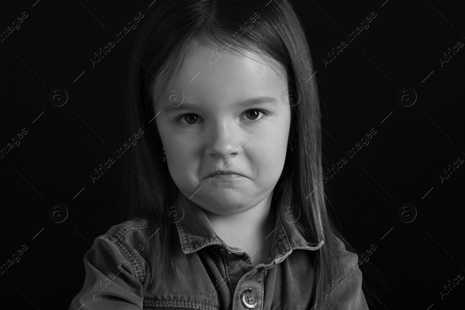 Photo of Portrait of sad girl on dark background, closeup. Black and white effect