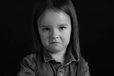 Portrait of sad girl on dark background, closeup. Black and white effect