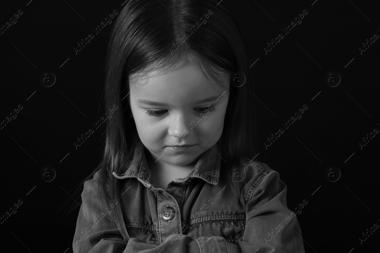 Photo of Portrait of sad girl on dark background, closeup. Black and white effect