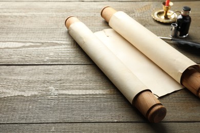 Photo of Sheet of old parchment paper with handles and inkwell on wooden table, space for text