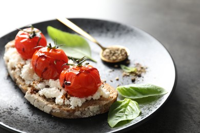 Photo of Delicious ricotta bruschetta with sun dried tomatoes, sauce and basil on grey table, closeup