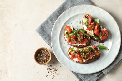 Photo of Delicious bruschettas with ricotta cheese, tomatoes, arugula and peppercorns on light table, flat lay. Space for text