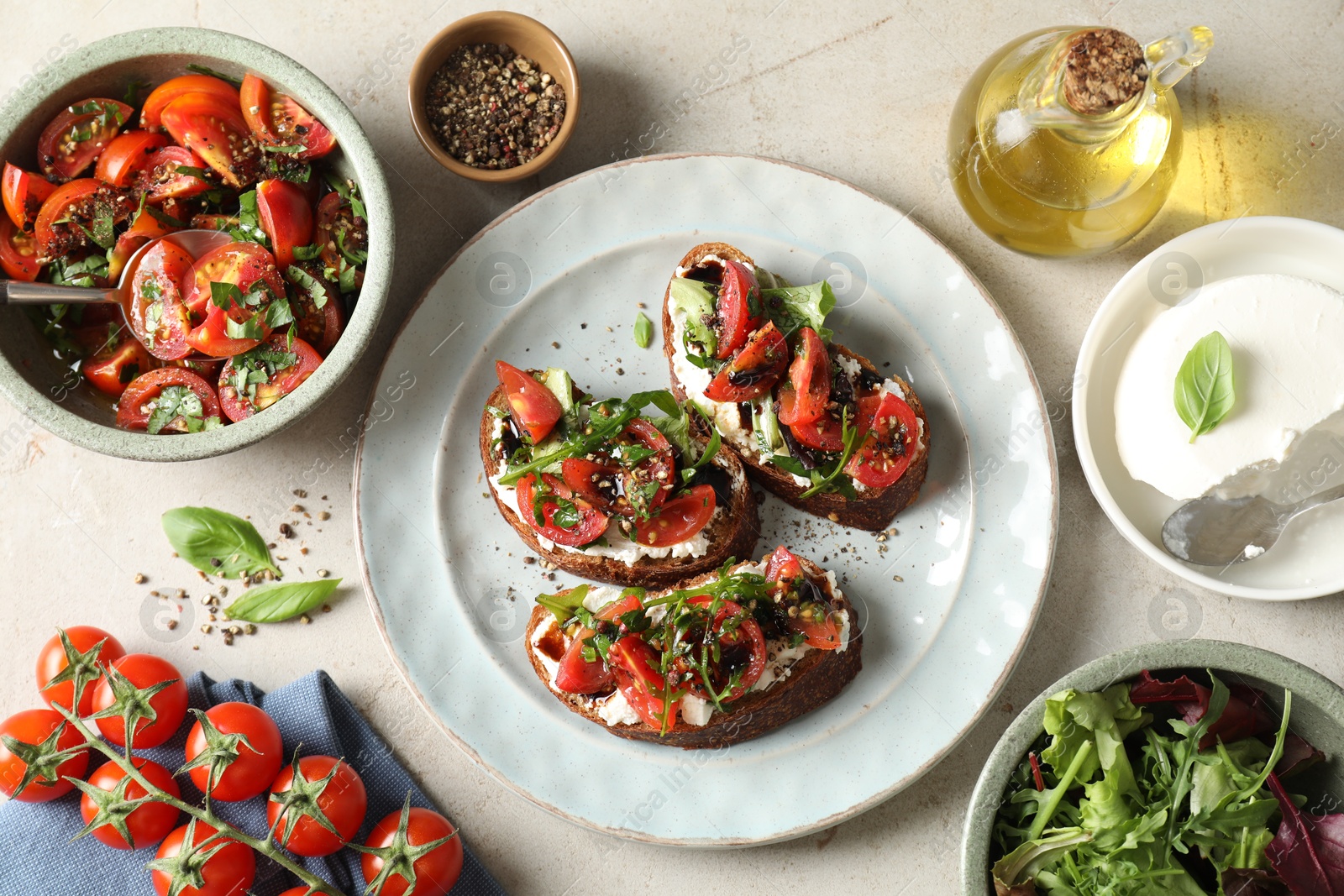 Photo of Delicious bruschettas with ricotta cheese, tomatoes, arugula, salad and peppercorns on light table, flat lay