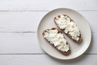 Bruschettas with ricotta cheese on white wooden table, top view. Space for text