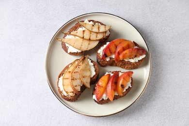 Delicious bruschettas with ricotta cheese on light grey table, top view