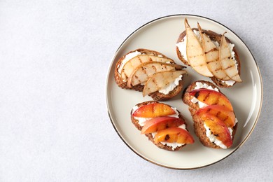 Delicious bruschettas with ricotta cheese on light grey table, top view. Space for text