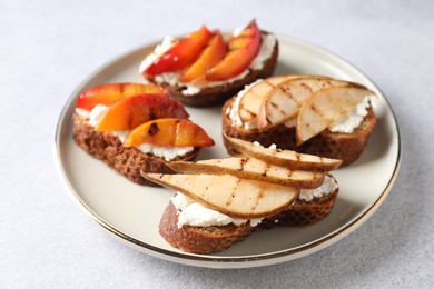 Delicious bruschettas with ricotta cheese on light grey table, closeup