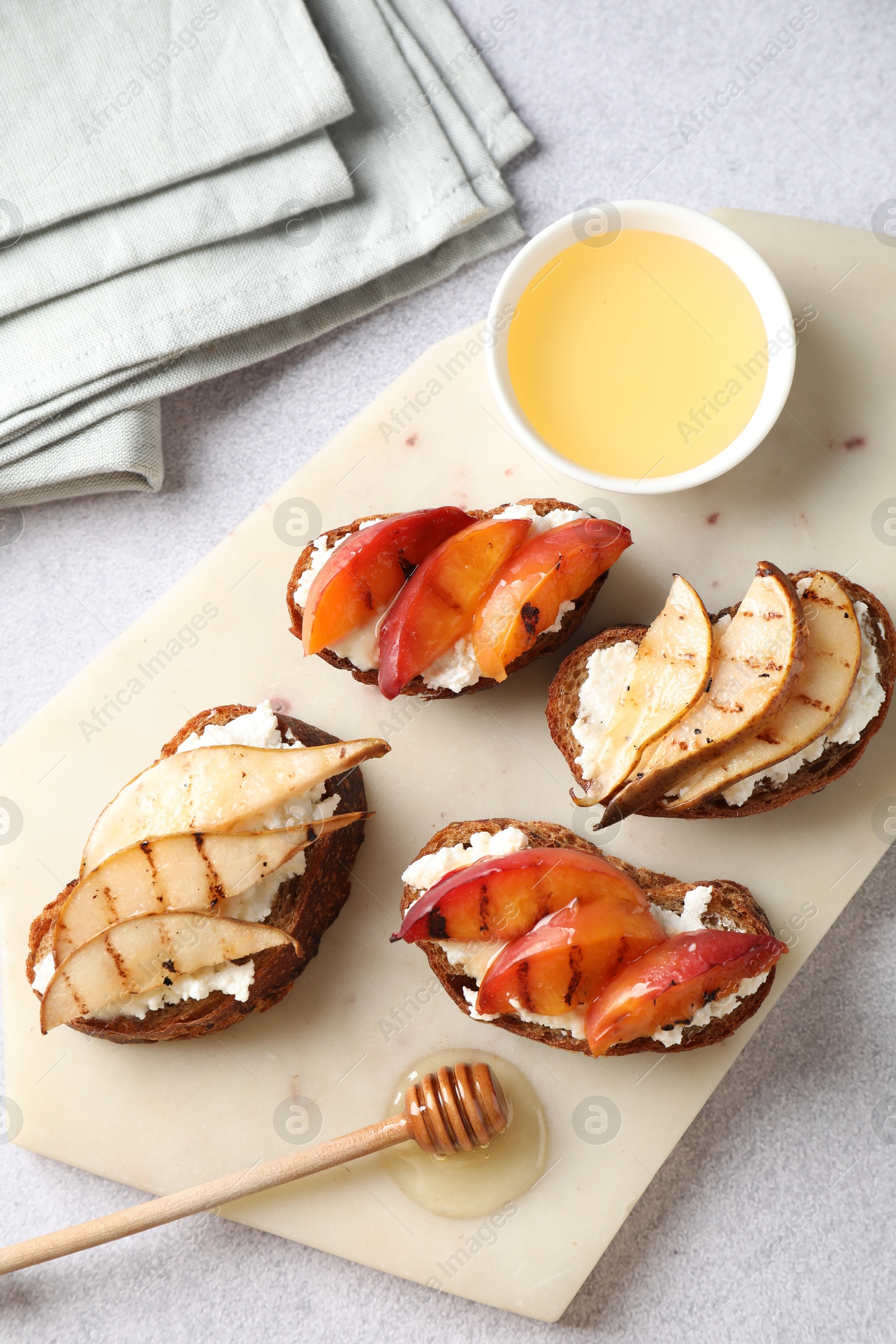 Photo of Delicious bruschettas with ricotta cheese and honey on light grey table, top view