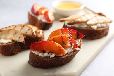 Photo of Delicious bruschettas with ricotta cheese and honey on light grey table, closeup