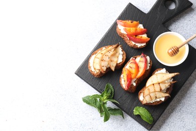 Photo of Delicious bruschettas with ricotta cheese and honey on light grey table, top view. Space for text