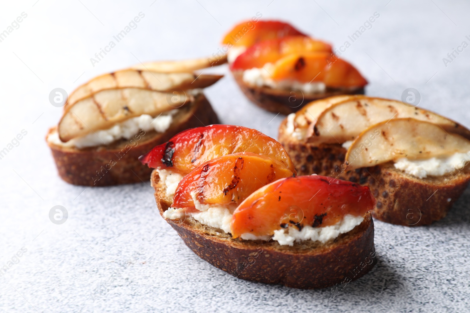 Photo of Delicious bruschettas with ricotta cheese on light grey table, closeup