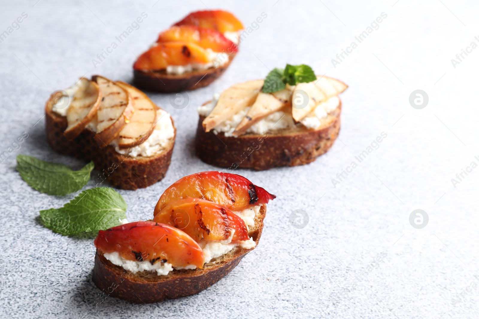 Photo of Delicious bruschettas with ricotta cheese on light grey table, closeup