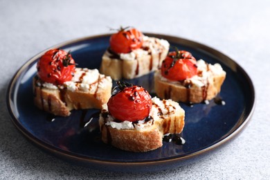 Photo of Bruschettas with ricotta cheese, tomatoes and balsamic sauce on grey table, closeup