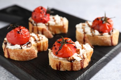 Photo of Bruschettas with ricotta cheese, tomatoes and balsamic sauce on grey table, closeup