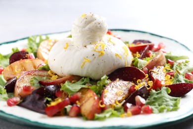 Plate with fresh burrata salad on table, closeup