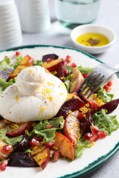 Plate with fresh burrata salad on table, closeup