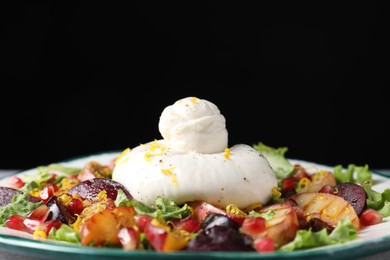 Photo of Plate with fresh burrata salad on plate against black background, closeup