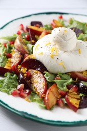 Plate with fresh burrata salad on white wooden table, closeup