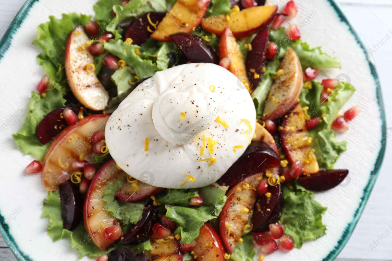 Photo of Plate with fresh burrata salad on white table, top view