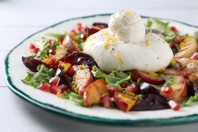 Photo of Plate with fresh burrata salad on white wooden table, closeup